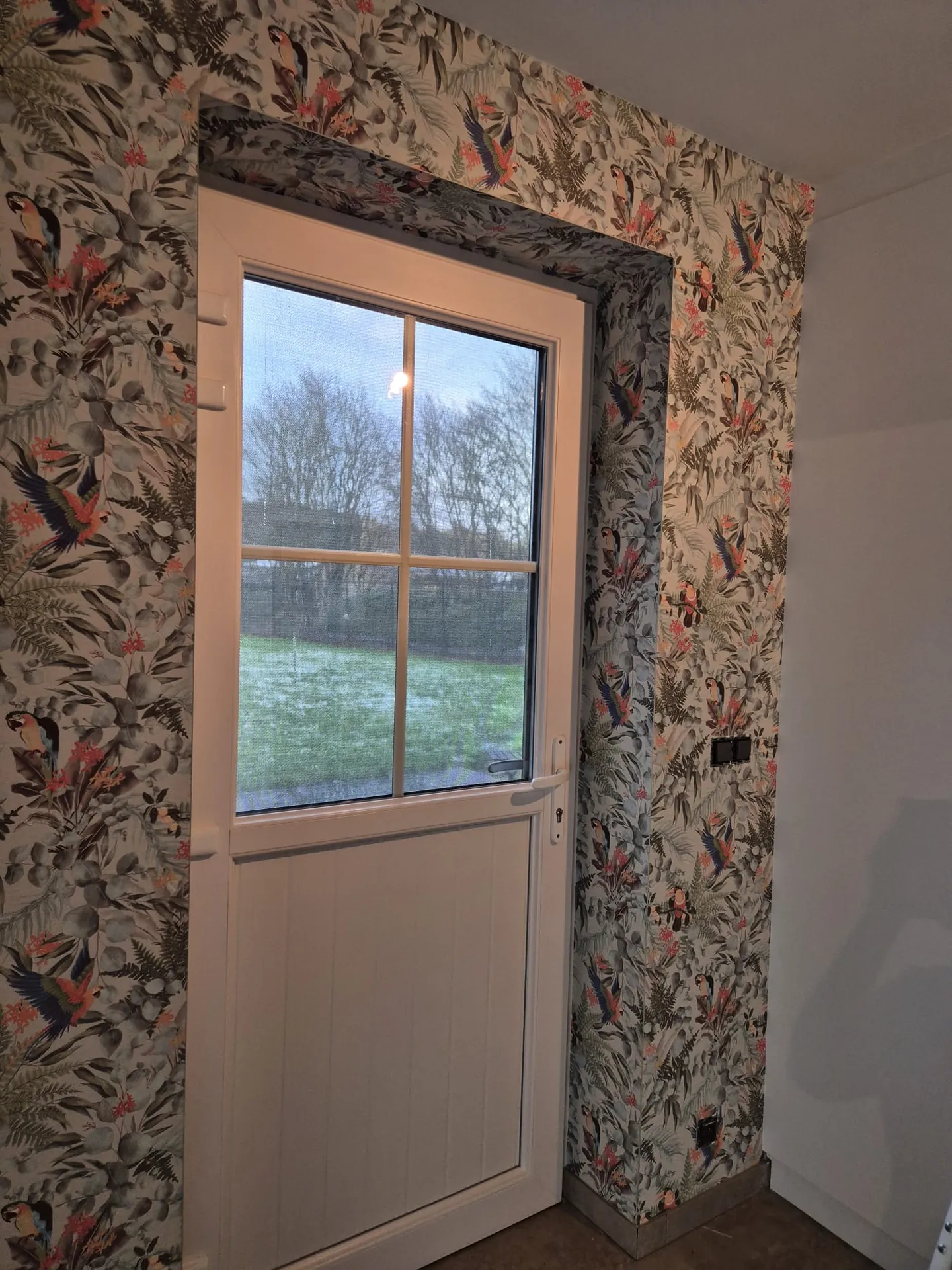 Behangwerk: tropisch behang rond een deur met raam in de Kempen