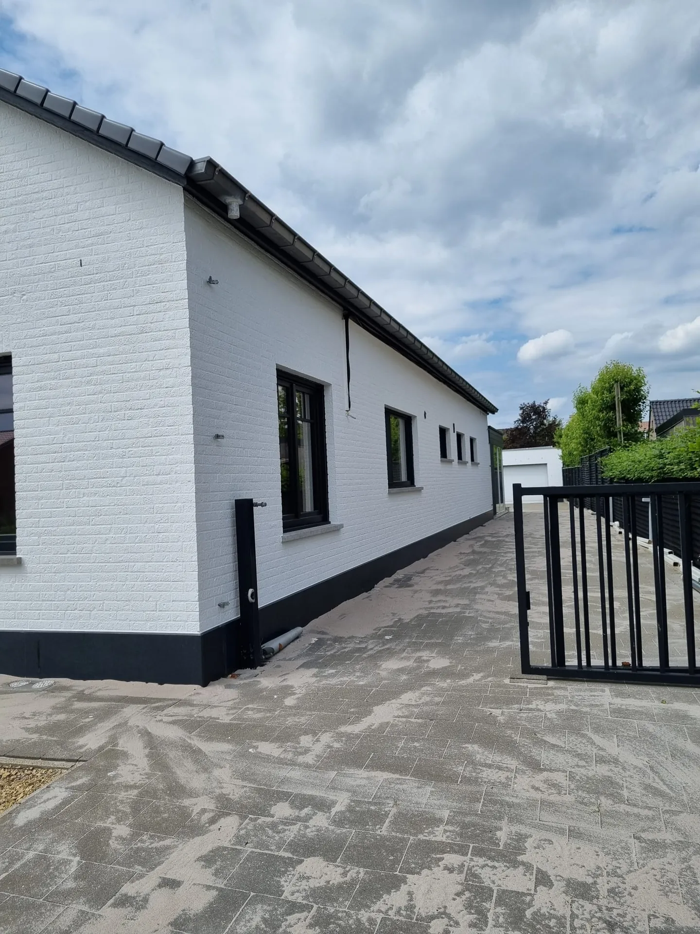 Buitenschilderwerk: witte gevel langs de oprit in de Kempen